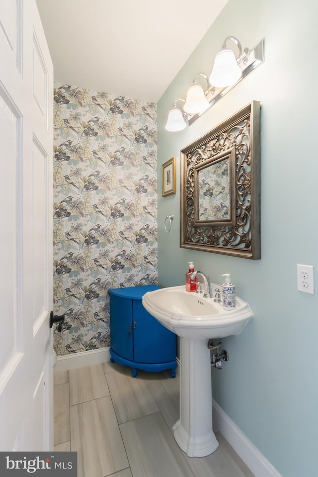 bathroom with wallpapered walls and baseboards