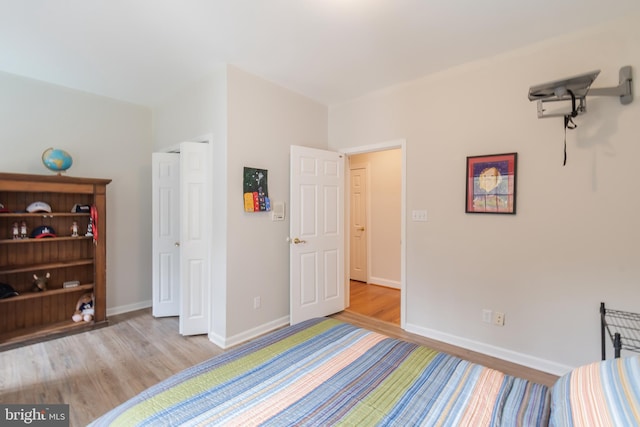 bedroom featuring baseboards and wood finished floors