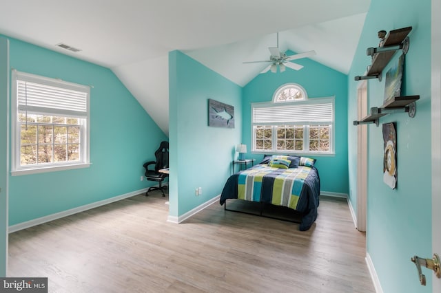 bedroom with vaulted ceiling, visible vents, baseboards, and wood finished floors