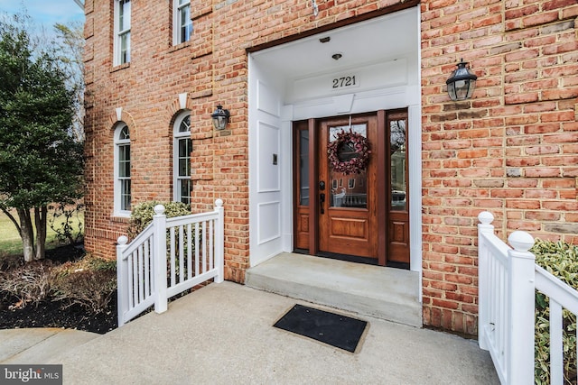 view of exterior entry featuring brick siding