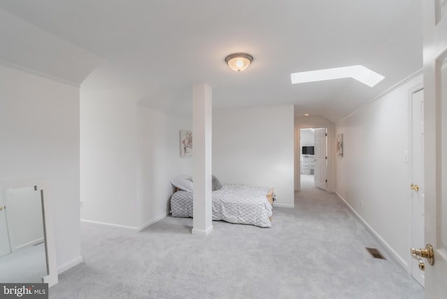 bedroom featuring lofted ceiling with skylight, baseboards, visible vents, and carpet floors