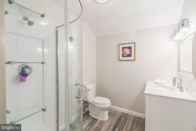 bathroom featuring a shower stall, baseboards, toilet, wood finished floors, and vanity