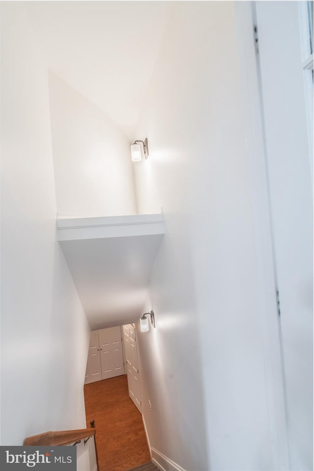 staircase with vaulted ceiling and wood finished floors