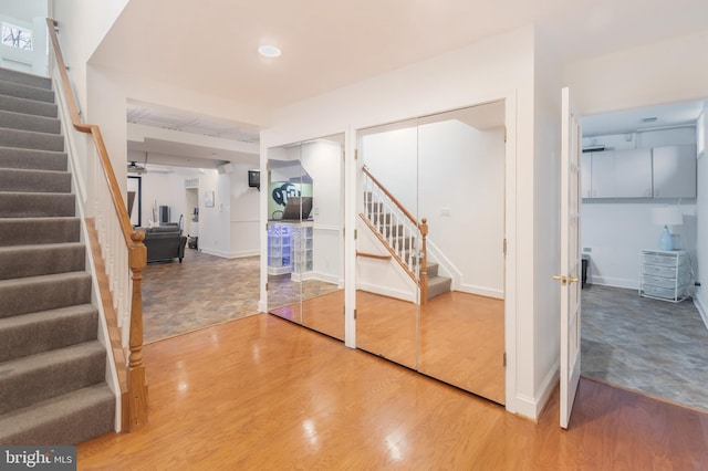 finished basement featuring stairway, baseboards, and wood finished floors