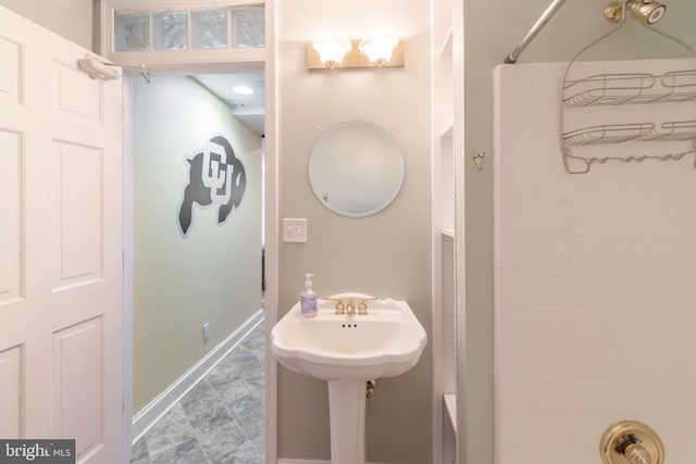 bathroom with baseboards and walk in shower