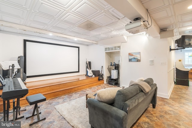 home theater room featuring baseboards and an ornate ceiling