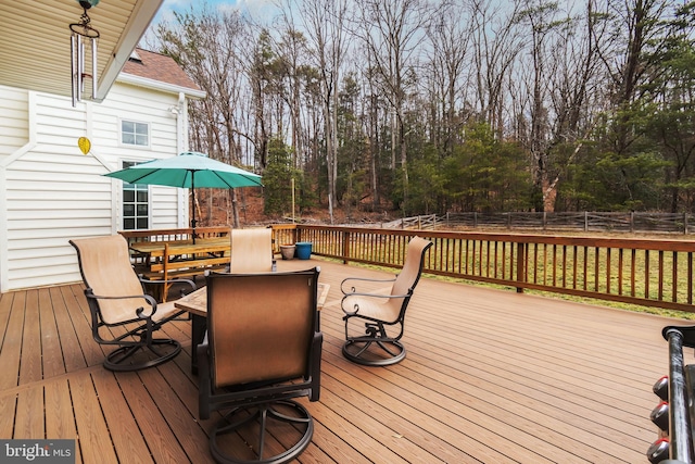 wooden terrace featuring outdoor dining area and fence