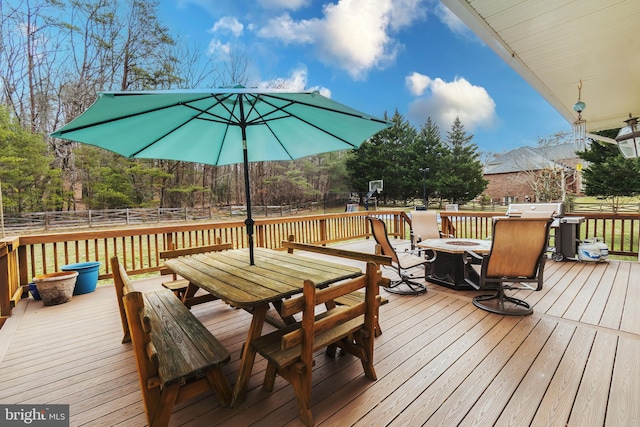 deck with a grill, an outdoor fire pit, and fence