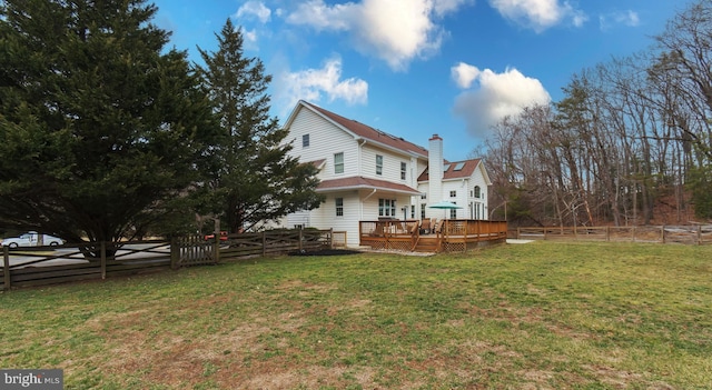 rear view of property with a yard, a deck, and a fenced backyard