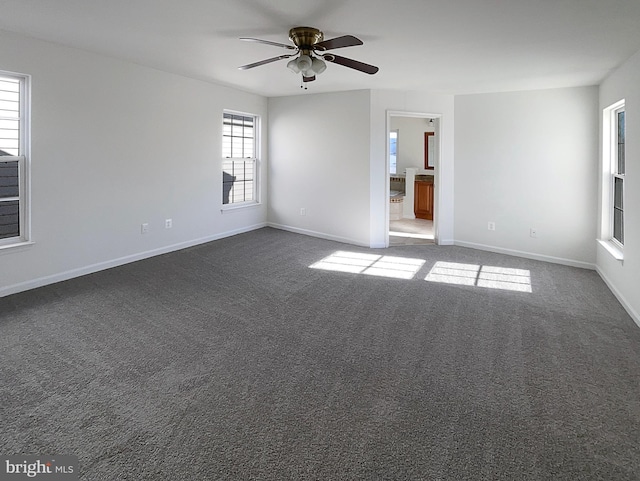 unfurnished room featuring dark colored carpet and ceiling fan