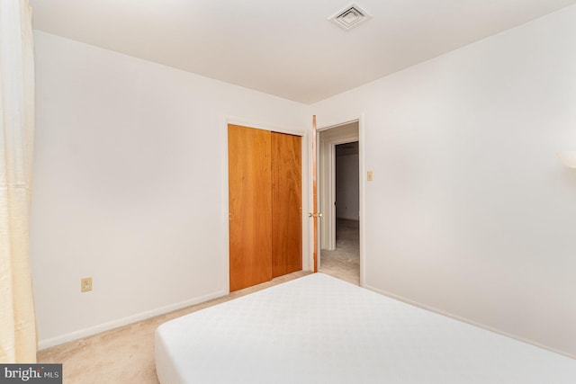 unfurnished bedroom with a closet and light carpet