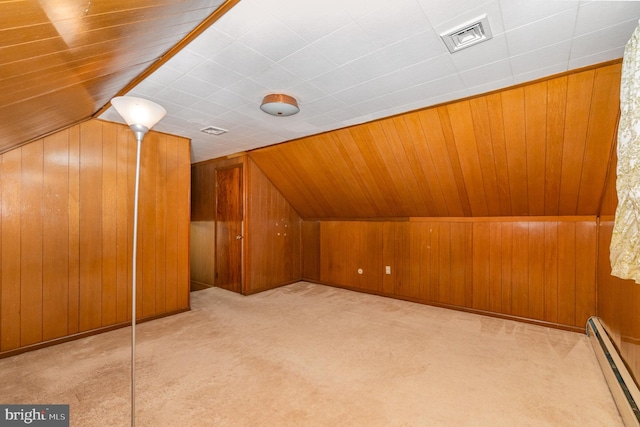 additional living space with baseboard heating, light colored carpet, lofted ceiling, and wooden walls