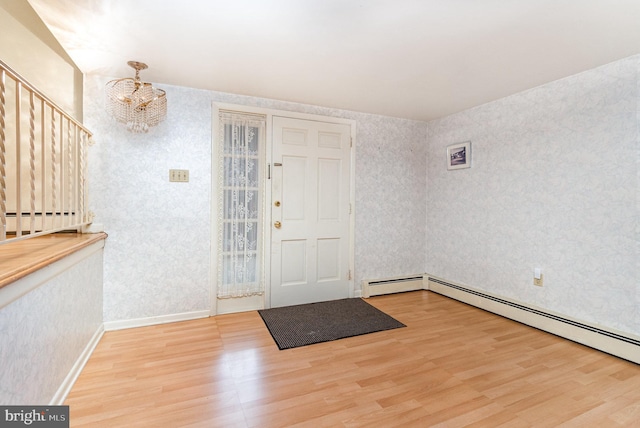 entryway featuring an inviting chandelier, wood-type flooring, and a baseboard heating unit