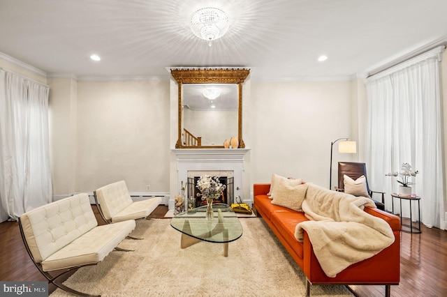 living room with ornamental molding, wood-type flooring, and baseboard heating