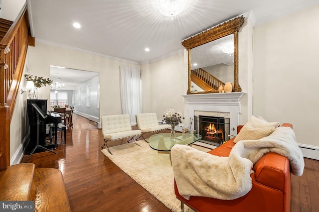 living room featuring hardwood / wood-style flooring, ornamental molding, and a notable chandelier