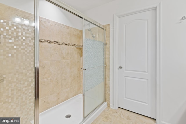 bathroom with tile patterned flooring and a shower stall