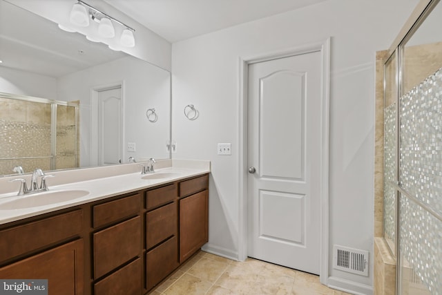 full bathroom featuring double vanity, a shower stall, visible vents, and a sink