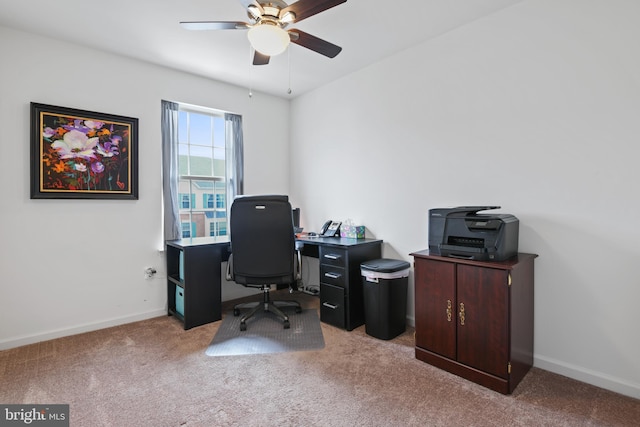 carpeted home office featuring a ceiling fan and baseboards