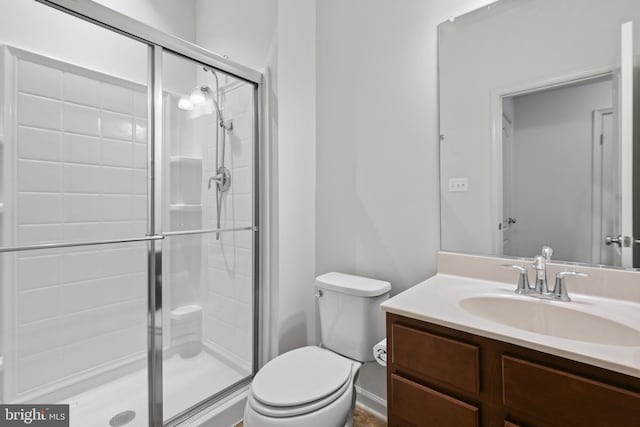 bathroom with a stall shower, vanity, and toilet