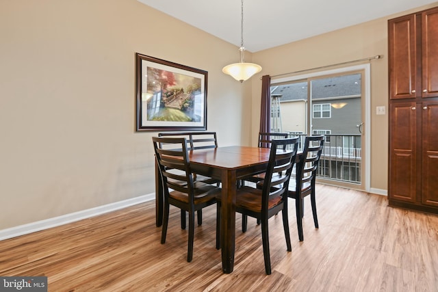 dining area featuring light wood-type flooring and baseboards