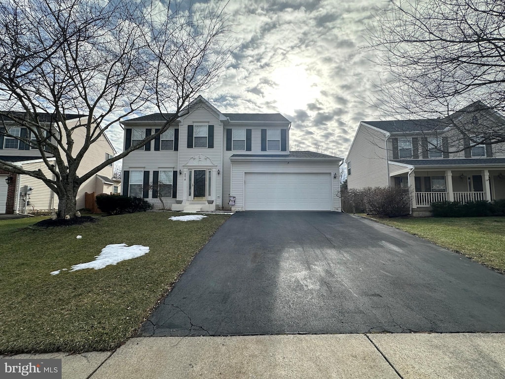 view of front of house featuring a garage, a front yard, and covered porch