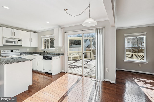 kitchen featuring dark hardwood / wood-style floors, white cabinets, hanging light fixtures, ornamental molding, and white appliances