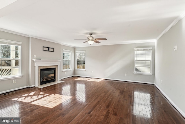 unfurnished living room featuring dark wood-type flooring, plenty of natural light, a premium fireplace, and crown molding