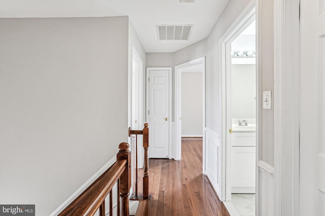 corridor with sink and hardwood / wood-style flooring