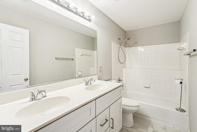 full bathroom featuring vanity, tiled shower / bath, and toilet