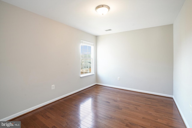 unfurnished room with dark hardwood / wood-style flooring