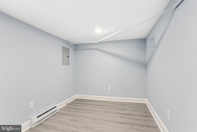 spare room with electric panel, baseboard heating, and light hardwood / wood-style floors