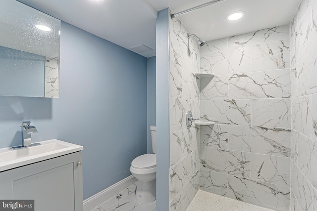 bathroom with vanity, toilet, and a tile shower