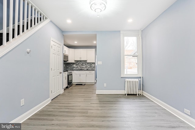 interior space featuring radiator and light hardwood / wood-style flooring