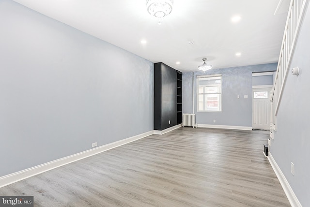 unfurnished room with radiator and light hardwood / wood-style floors