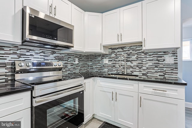 kitchen with backsplash, stainless steel appliances, sink, and white cabinets