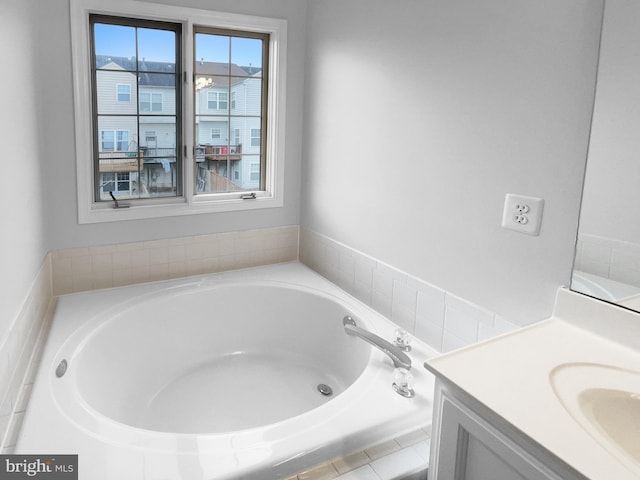 bathroom featuring vanity and a relaxing tiled tub