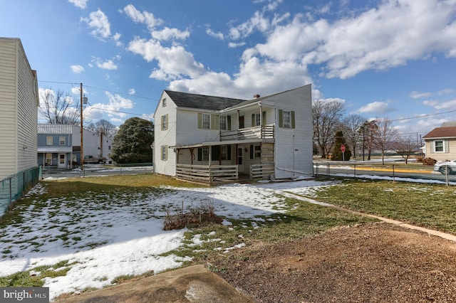 snow covered rear of property featuring a balcony