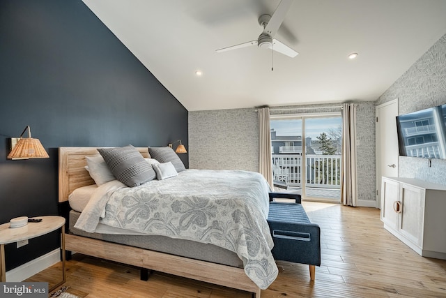 bedroom featuring lofted ceiling, wood finished floors, baseboards, access to outside, and wallpapered walls