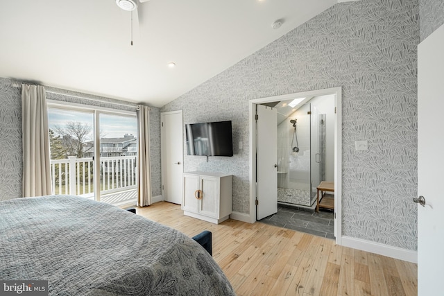 bedroom featuring wallpapered walls, light wood finished floors, baseboards, connected bathroom, and lofted ceiling