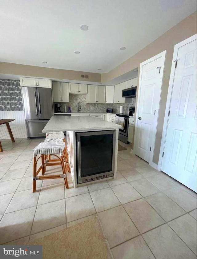 kitchen featuring light countertops, appliances with stainless steel finishes, wine cooler, and light tile patterned flooring