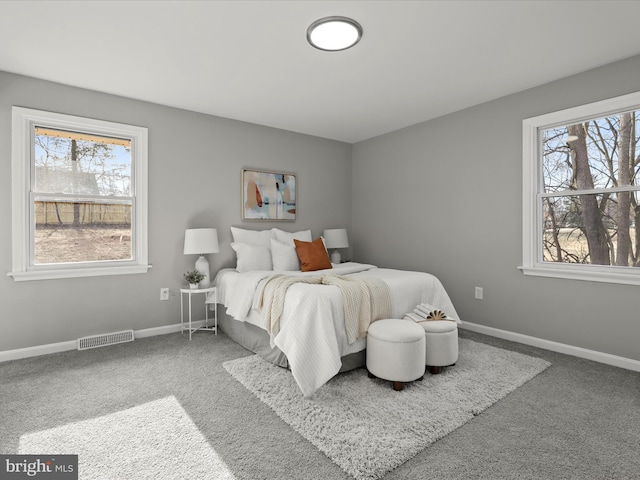 carpeted bedroom with multiple windows, visible vents, and baseboards