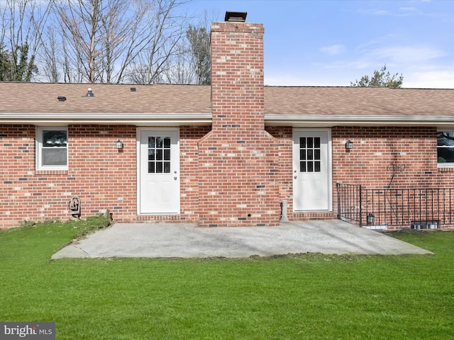 rear view of house with a yard, brick siding, and a chimney