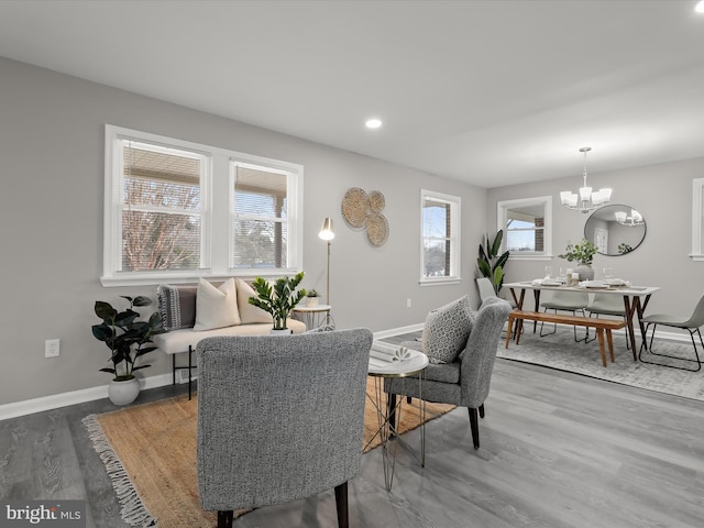 dining space with recessed lighting, a notable chandelier, baseboards, and wood finished floors