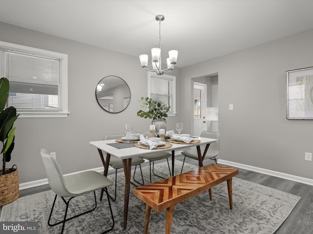 dining room with dark wood-style flooring, baseboards, and an inviting chandelier