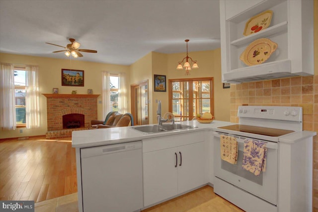 kitchen with white cabinetry, hanging light fixtures, white appliances, and kitchen peninsula