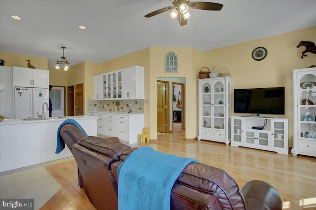 living room with ceiling fan and light wood-type flooring