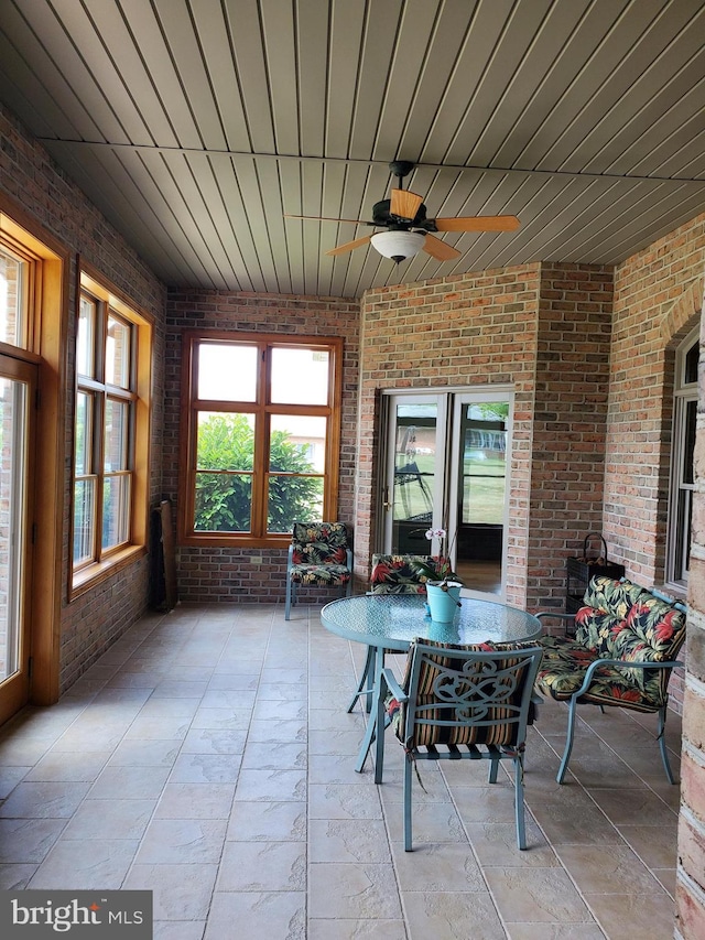 unfurnished sunroom with ceiling fan