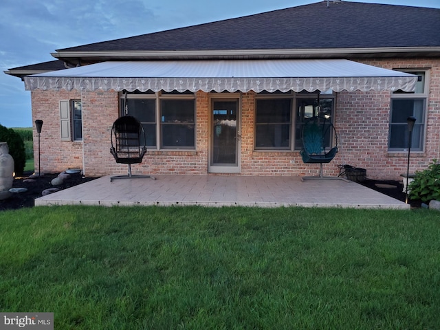 back of property featuring a yard and a patio area