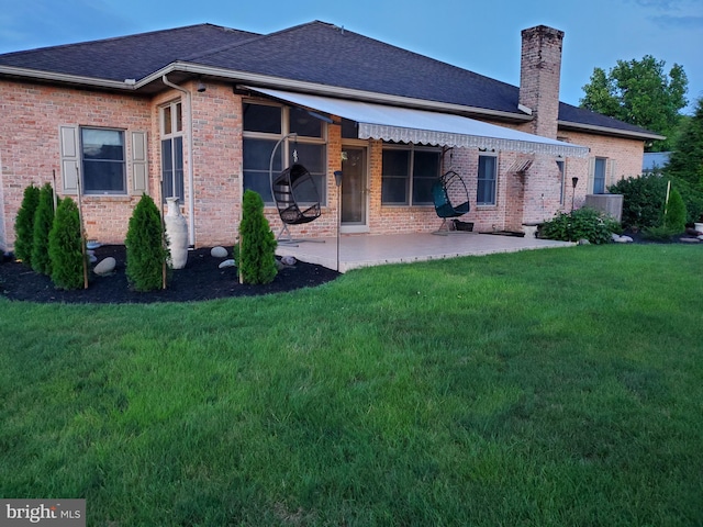 back of house with a lawn and a patio area