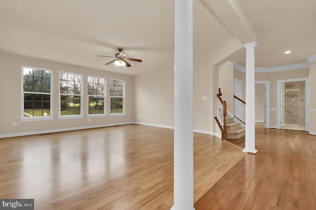 unfurnished living room featuring ornate columns, ceiling fan, crown molding, and light wood-type flooring